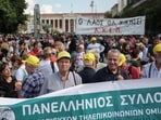Protesters gather behind banners during a demonstration marking a 24-hour general strike against a labour reform extending a 13-hour workday to workers with one job, in Athens, Greece