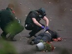 Ambulance incident workers process the body of a man, believed to be the attacker, at the scene