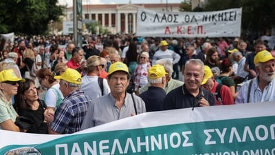 Protesters gather behind banners during a demonstration marking a 24-hour general strike against a labour reform extending a 13-hour workday to workers with one job, in Athens, Greece (REUTERS)