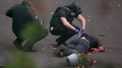 Ambulance incident workers process the body of a man, believed to be the attacker, at the scene (REUTERS)