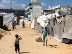 A child pulls a cart loaded with water containers past tents at a make-shift camp for people displaced by conflict in Khan Yunis in the southern Gaza Strip. A child pulls a cart loaded with water containers past tents at a make-shift camp for people displaced by conflict in Khan Yunis in the southern Gaza Strip.