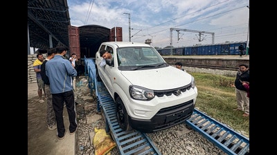 Members of a Maruti Suzuki dealership unload cars from a freight train after the first train carrying 116 vehicles from the company's Manesar plant arrives, in Anantnag, on Friday. (PTI)
