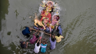 Hindu devotees immerse an idol of the Hindu goddess Durga in the Buriganga River in Dhaka on October 2, 2025, on the last day of the 'Durga Puja' festival. (Representative image/AFP)