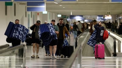 Passengers carry on inflatable mattresses that they were provided with to sleep at Munich International Airport in Munich, southern Germany, on early October 4, 2025, after reports of drone sightings again forced Munich airport. (AFP)