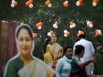 People stand near cutouts of Delhi chief minister Rekha Gupta 