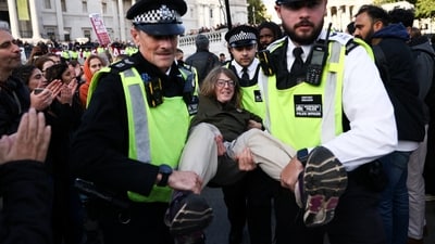 Police officers detain a protester during a mass demonstration organised by Defend Our Juries, against the British government's ban on Palestine Action, in London, Britain. (Reuters)