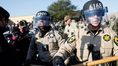 State law enforcement stand guard as hundreds of protesters gather near an Immigration and Customs Enforcement (ICE) facility opposing the detention of undocumented immigrants following President Donald Trump's order to increase federal presence and step up immigration enforcement through the Department of Homeland Security in Broadview, Illinois, on October 3, 2025. (Photo by OCTAVIO JONES / AFP) (AFP) State law enforcement stand guard as hundreds of protesters gather near an Immigration and Customs Enforcement (ICE) facility opposing the detention of undocumented immigrants following President Donald Trump's order to increase federal presence and step up immigration enforcement through the Department of Homeland Security in Broadview, Illinois, on October 3, 2025. (Photo by OCTAVIO JONES / AFP) (AFP)