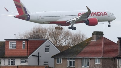 An Air India passenger plane flies near houses as it makes its landing approach. (Reuters/File)