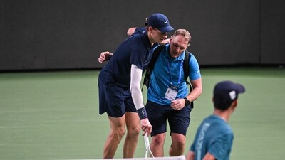 Jannik Sinner is helped by a medical trainer during his men's singles match against Tallon Griekspoor. (AFP)