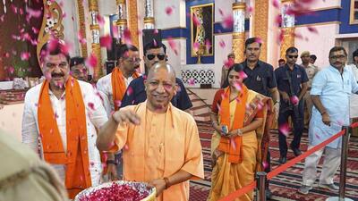 Uttar Pradesh chief minister Yogi Adityanath showering flowers on sanitation workers in Varanasi on Monday. (PTI PHOTO)
