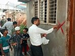 District administration officials marking a house with red cross in Sambhal’s Hatim Sarai area on Tuesday. (HT)