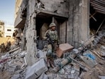 Israeli soldiers stand amid rubble, during the ongoing ground invasion against Palestinian group Hamas in the northern Gaza Strip