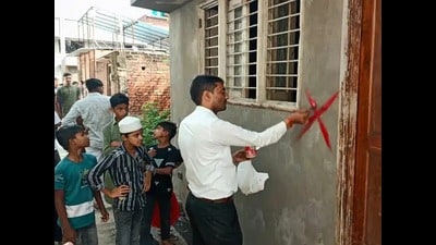 District administration officials marking a house with red cross in Sambhal’s Hatim Sarai area on Tuesday. (HT) District administration officials marking a house with red cross in Sambhal’s Hatim Sarai area on Tuesday. (HT)