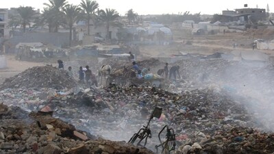 Displaced Palestinian children search of items that could be used as fuel for cooking amid a pile of burning garbage at the Bureij camp for refugees in the central Gaza Strip (AFP) Displaced Palestinian children search of items that could be used as fuel for cooking amid a pile of burning garbage at the Bureij camp for refugees in the central Gaza Strip (AFP)