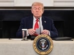 US President Donald Trump holds a note that was handed to him by US Secretary of State Marco Rubio during a roundtable on antifa
