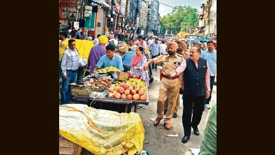 Senior deputy mayor Rakesh Parashar with cops during an anti-encroachment drive in Chaura Bazar on Wednesday. (HT Photo)