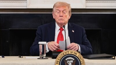 US President Donald Trump holds a note that was handed to him by US Secretary of State Marco Rubio during a roundtable on antifa (REUTERS)