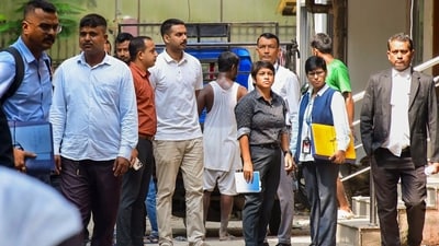 Late singer Zubeen Garg's cousin and Assam Police DSP Sandipan Garg, centre in white, is being produced at a court after his arrest in connection with the singer's death in Singapore last month. (PTI)