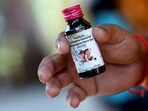 Nilesh Suryavanshi, 32, the father of a 3 year old child who has been admitted at the Government Medical College, holds a bottle of Coldrif cough syrup.