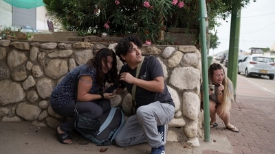 People take cover from incoming rocket fire from the Gaza Strip in Ashkelon, southern Israel. (Leo Correa/AP) People take cover from incoming rocket fire from the Gaza Strip in Ashkelon, southern Israel. (Leo Correa/AP)