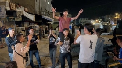 Palestinians celebrate on a street following the news that Israel and Hamas have agreed on Wednesday to the first phase of U.S. President Donald Trump's plan for Gaza, in Khan Younis (via REUTERS)