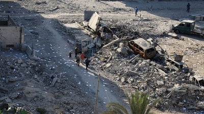 Palestinians walk near rubble following an Israeli raid, amid an Israeli military operation, in Gaza City (REUTERS)