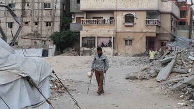 A Palestinian man with crutches seen walking next to rubble caused by Israel's bombardment of Gaza&nbsp; (REUTERS)