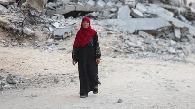 A Palestinian woman walks near rubble in Gaza city. Almost all buildings - residential, commercial and even hospitals have been targeted by the Israeli military during the three-year war. (REUTERS)