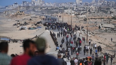 Displaced Palestinians gather on the coastal road near Wadi Gaza after the announcement that Israel and Hamas had agreed to the first phase of a peace plan to pause the fighting (AP) Displaced Palestinians gather on the coastal road near Wadi Gaza after the announcement that Israel and Hamas had agreed to the first phase of a peace plan to pause the fighting (AP)