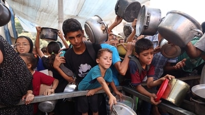 Palestinians queue to receive a hot meal from a charity kitchen in the Nuseirat refugee camp. The UN and several UN-backed agencies have declared famine in parts of Gaza as Israel continous its aid blockade in the Palesitnian strip. (AFP) Palestinians queue to receive a hot meal from a charity kitchen in the Nuseirat refugee camp. The UN and several UN-backed agencies have declared famine in parts of Gaza as Israel continous its aid blockade in the Palesitnian strip. (AFP)