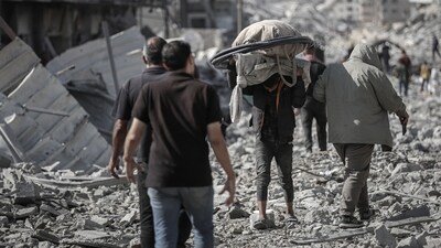 Palestinians walk over rubble after the ceasefire in Gaza City on Friday, October 10 (Bloomberg) Palestinians walk over rubble after the ceasefire in Gaza City on Friday, October 10 (Bloomberg)
