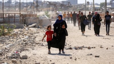 A woman walks with a girl on the way to Gaza City through the so-called "Netzarim corridor" from Nuseirat in the central Gaza Strip. (AFP) A woman walks with a girl on the way to Gaza City through the so-called "Netzarim corridor" from Nuseirat in the central Gaza Strip. (AFP)