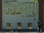 Men walk next to the sign near the International Congress Center, during preparations for an international summit on Gaza, amid a ceasefire between Israel and Hamas, at the Red Sea resort of Sharm el-Sheikh, Egypt, October 11, 2025.
