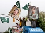 People carry posters showing the pictures of chief of army staff of Pakistan Asim Munir, (R) along with Ahmed Sharif Chaudhry, director general of Inter-Service Public Relations wing of Pakistan Armed Forces.