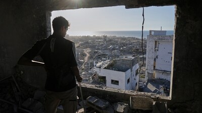 A man looks out from his damaged apartment at the destruction in his neighborhood in Gaza City, Friday, Oct. 10, 2025, after returning home following an agreement between Israel and Hamas on a ceasefire and the release of remaining hostages. (AP) A man looks out from his damaged apartment at the destruction in his neighborhood in Gaza City, Friday, Oct. 10, 2025, after returning home following an agreement between Israel and Hamas on a ceasefire and the release of remaining hostages. (AP)