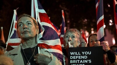 A demonstrator holds a placard as people gather outside Downing Street to demand stronger government action against antisemitism, one week after the deadly Manchester synagogue attack, in London, on October 9. (REUTERS)