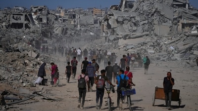 Displaced Palestinians walk past destroyed buildings as they return to their homes in the Zeitoun neighborhood of Gaza City on Friday. (Jehad Alshrafi/AP) Displaced Palestinians walk past destroyed buildings as they return to their homes in the Zeitoun neighborhood of Gaza City on Friday. (Jehad Alshrafi/AP)