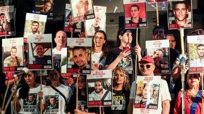 People hold placards with pictures of hostages who taken hostage in the deadly October 7, 2023 attack by Hamas. (REUTERS)