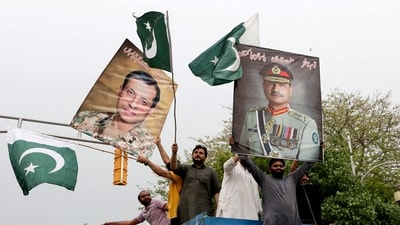 People carry posters showing the pictures of chief of army staff of Pakistan Asim Munir, (R) along with Ahmed Sharif Chaudhry, director general of Inter-Service Public Relations wing of Pakistan Armed Forces. (REUTERS FILE)