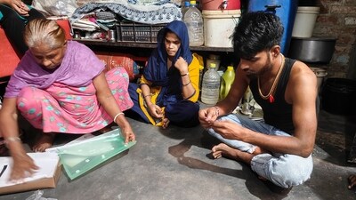Family members of Sanjay, a sanitation worker who was injured while cleaning a sewer in 2020 and has since been battling with lung and kidney related diseases, at their residence at Seemapuri area in New Delhi. (Uzmi Ather/PTI) Family members of Sanjay, a sanitation worker who was injured while cleaning a sewer in 2020 and has since been battling with lung and kidney related diseases, at their residence at Seemapuri area in New Delhi. (Uzmi Ather/PTI)