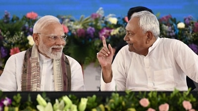 Prime Minister Narendra Modi speaks with Nitish Kumar, chief minister of Bihar, during a public meeting in Gaya on August 22, 2025. (AFP)