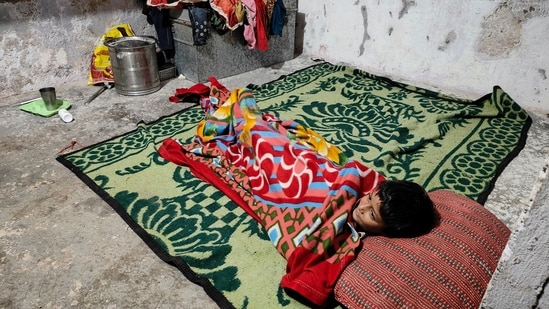 Kajal, the daughter of sanitation worker Sher Singh who sustained injuries while cleaning a sewer in 2019 and succumbed to his injuries five years later, rests at her residence, in New Delhi.(Uzmi Ather/PTI)