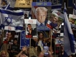 People holding up portraits of Israeli hostages held in Gaza and waving Israeli national flags, along with a poster depicting US President Donald Trump, gather at Hostage Square in Tel Aviv.