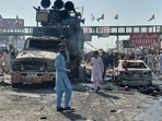 Local residents stand by burnt vehicles after police in Pakistan clashed with thousands of protesters during a march in support of Palestinians, in Muridke near Lahore, Pakistan, Monday, Oct. 13, 2025.