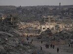 Palestinians walk among destroyed buildings in Gaza City on Sunday. (AP) Palestinians walk among destroyed buildings in Gaza City on Sunday. (AP)