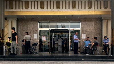 FILE: Police officers guard at the main entrance door to a building where Zion church is located after the church was shutdown by authorities in Beijing, Sept. 11, 2018. (AP Photo/Andy Wong, File) (AP)