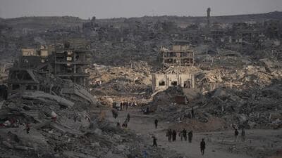 Palestinians walk among destroyed buildings in Gaza City on Sunday. (AP) Palestinians walk among destroyed buildings in Gaza City on Sunday. (AP)