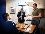 Chris Bird holds an umbrella for Hans Niemann and Wesley So.(X)