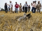 Police personnel and others stand near metal debris at an open field at Makhan Windi village, amid tension between India and Pakistan in the wake of ‘Operation Sindoor’, in Amritsar district, Punjab, Thursday, May 8, 2025. (PTI)