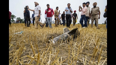 Police personnel and others stand near metal debris at an open field at Makhan Windi village, amid tension between India and Pakistan in the wake of ‘Operation Sindoor’, in Amritsar district, Punjab, Thursday, May 8, 2025. (PTI) Police personnel and others stand near metal debris at an open field at Makhan Windi village, amid tension between India and Pakistan in the wake of ‘Operation Sindoor’, in Amritsar district, Punjab, Thursday, May 8, 2025. (PTI)